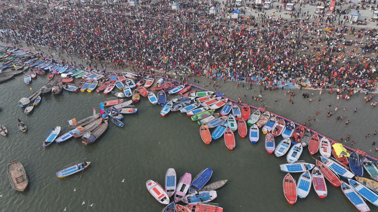 Aerial shot showcasing the bustling crowd and colorful boats at Kumbh Mela in Prayagraj.