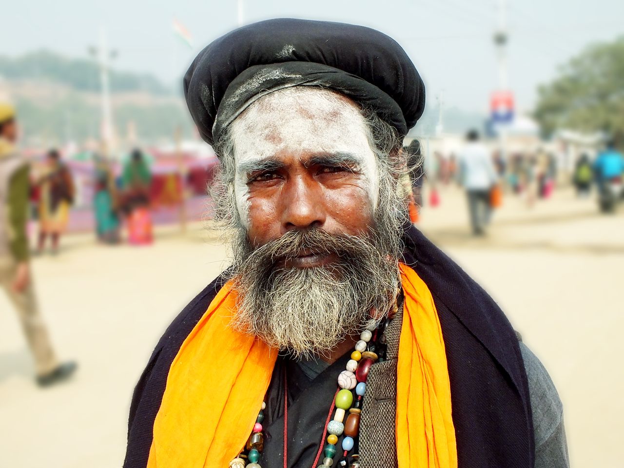 Close-up portrait of a traditional Sadhu wearing vibrant clothing in Prayagraj, India.